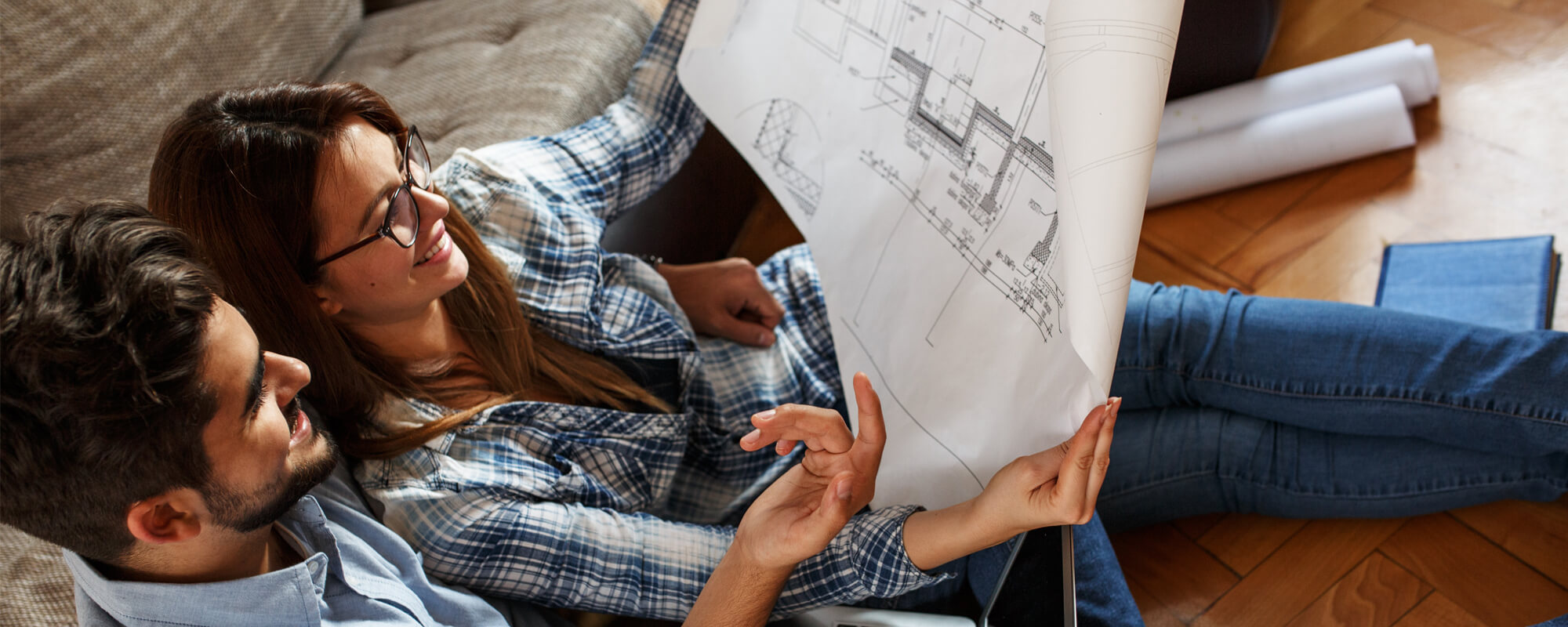 Two people reading building plans together at home